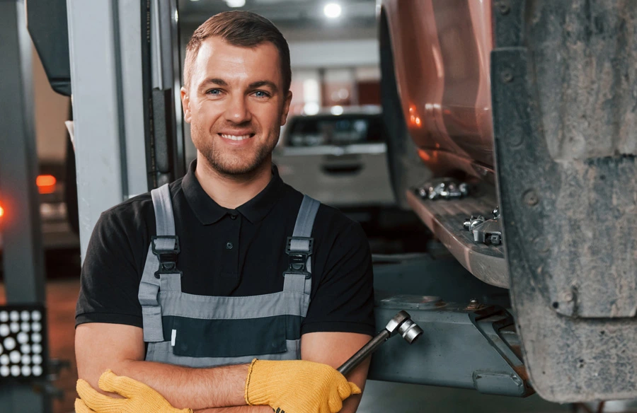 student holding wrench and smiling