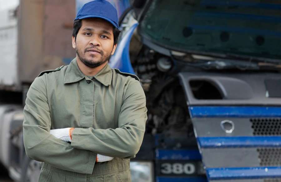 student standing next to truck with arms crossed
