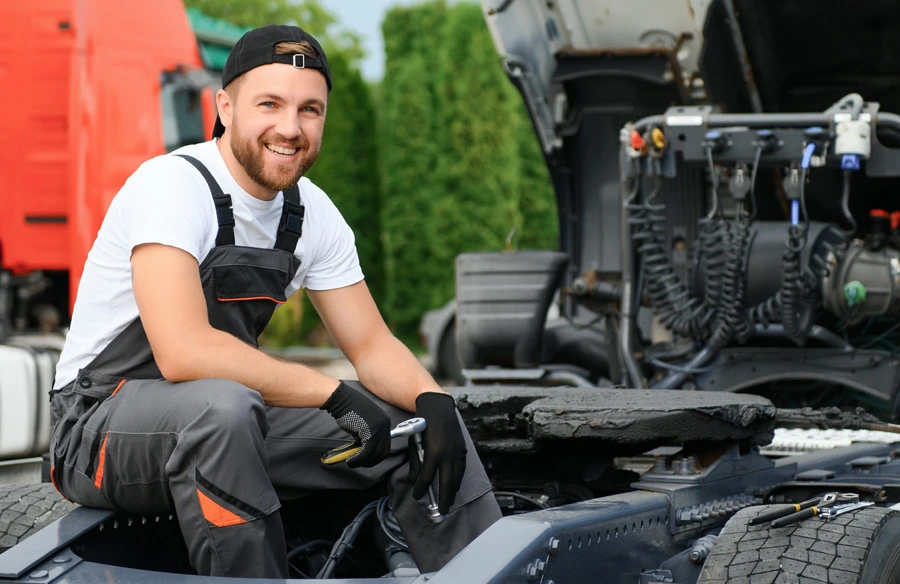 student smiling while working on truck