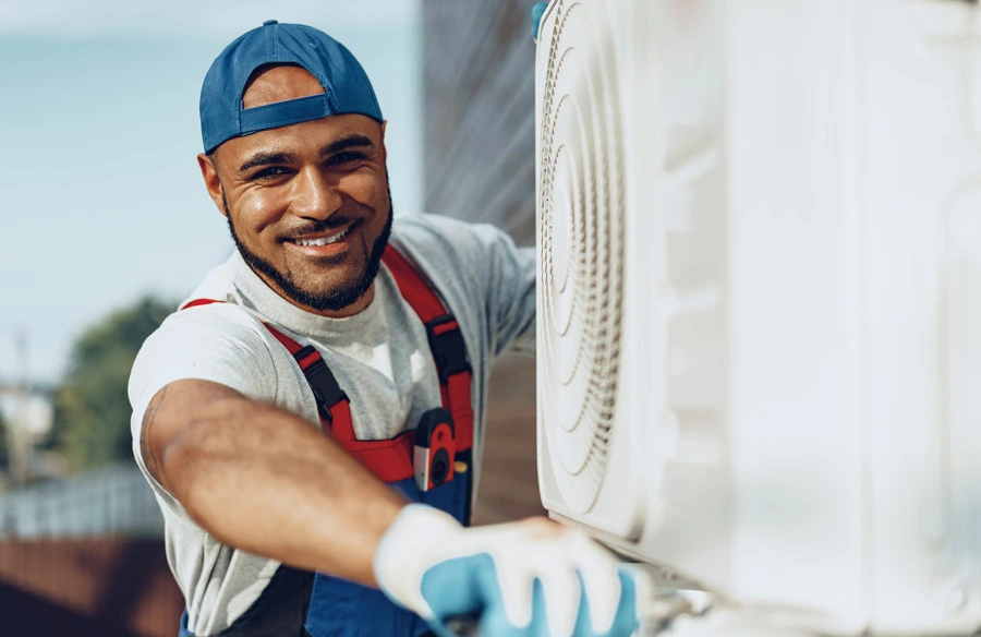 male working on AC and smiling